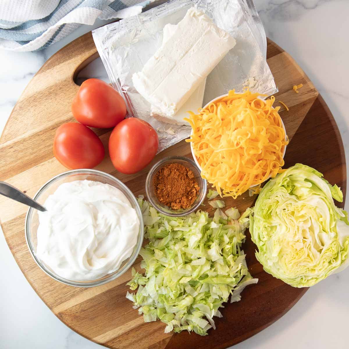 ingredients for taco dip including cream cheese, sour cream and taco seasoning
