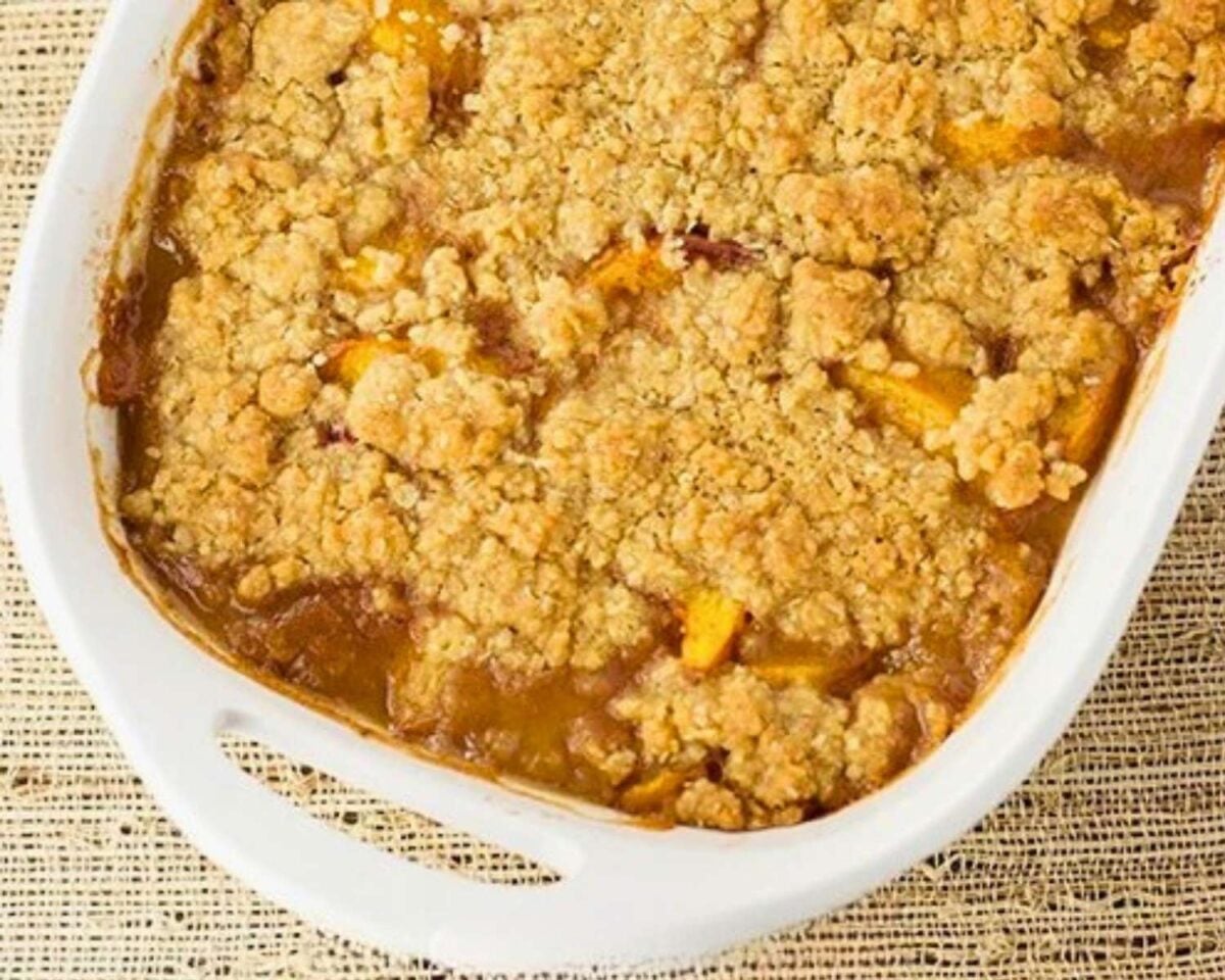 baked peach crisp bubbling in a 9x13 inch dish.