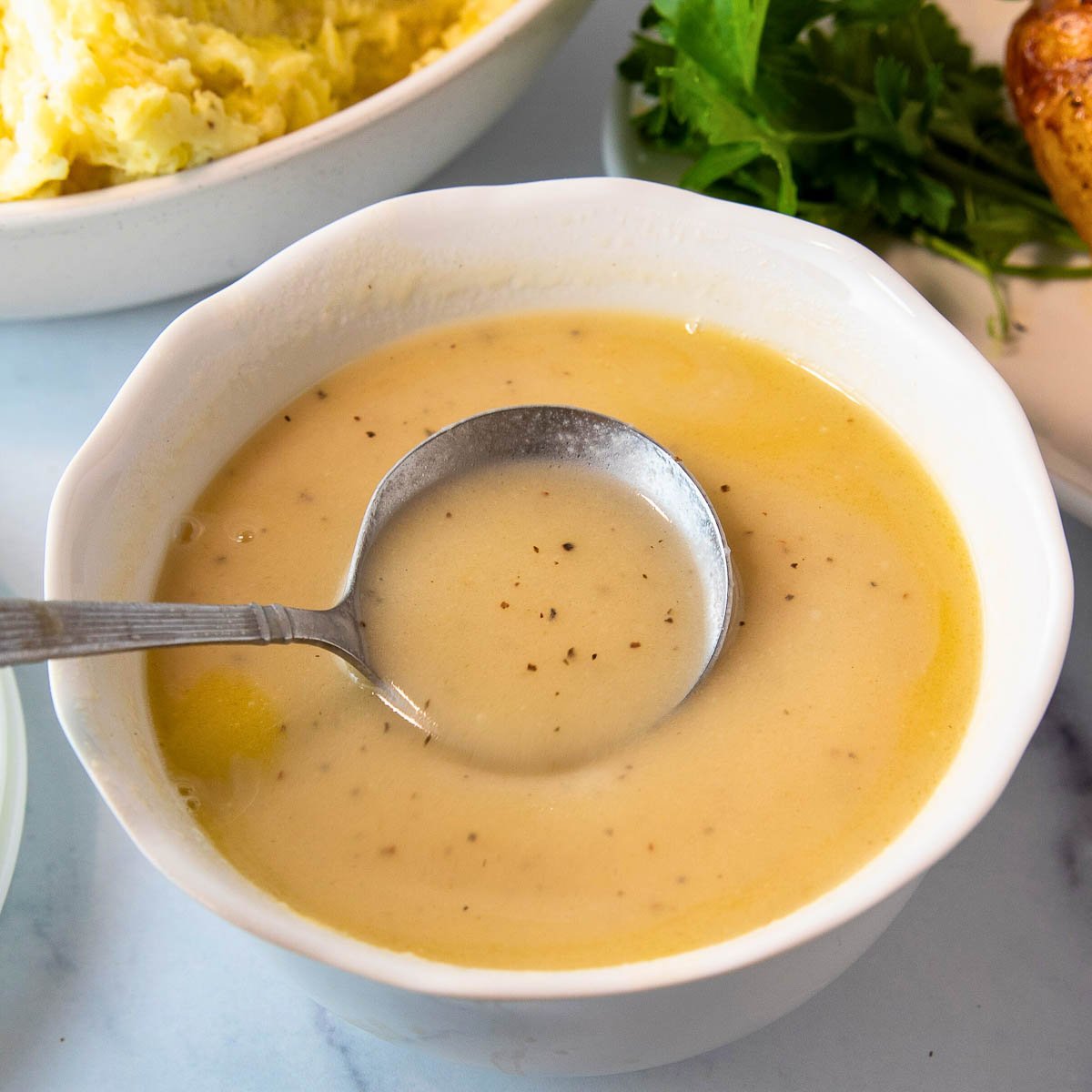 bowl of gravy for thanksgiving with a ladle. 