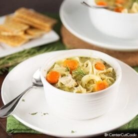 bowl of chicken noodle soup with a spoon sitting beside