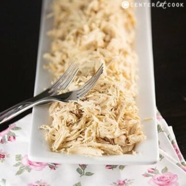 plate of easy slow cooker shredded chicken with two forks