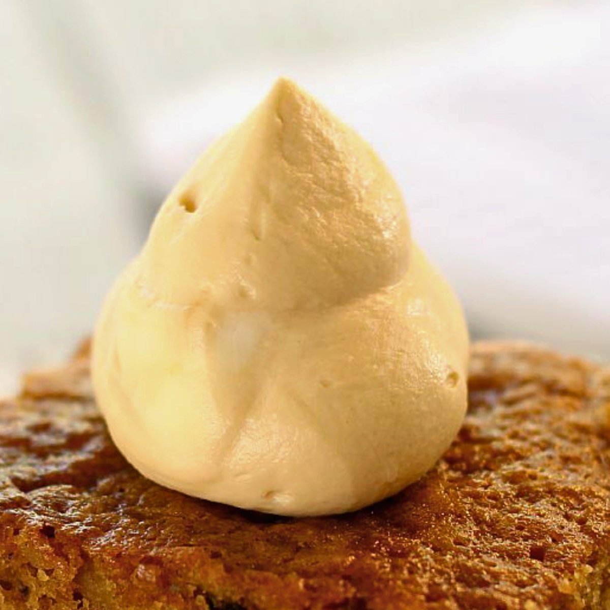 homemade caramel whipped cream atop pumpkin walnut cake