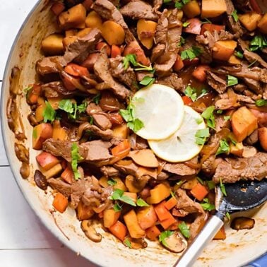 easy one-pan steak and potatoes in a skillet with carrots, mushrooms and a savory sauce.