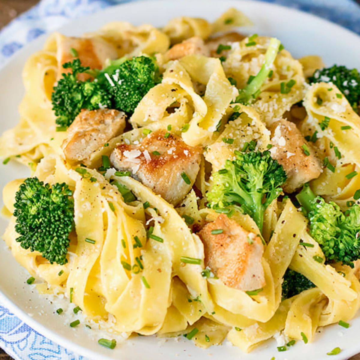 Close-up of fettuccine Alfredo with chicken and broccoli on a plate.