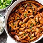 baked chicken teriyaki with bowl of broccoli and bowl of rice sitting beside.