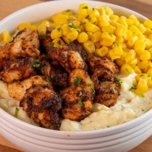 air fryer chicken bites in a bowl with corn and potatoes