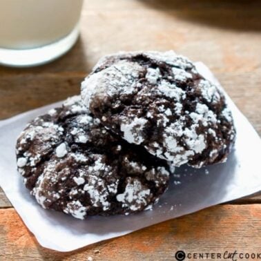 stack of cakey chocolate crinkle cookies coated in powdered sugar on a plate