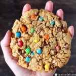 person's hand holding a giant monster cookie