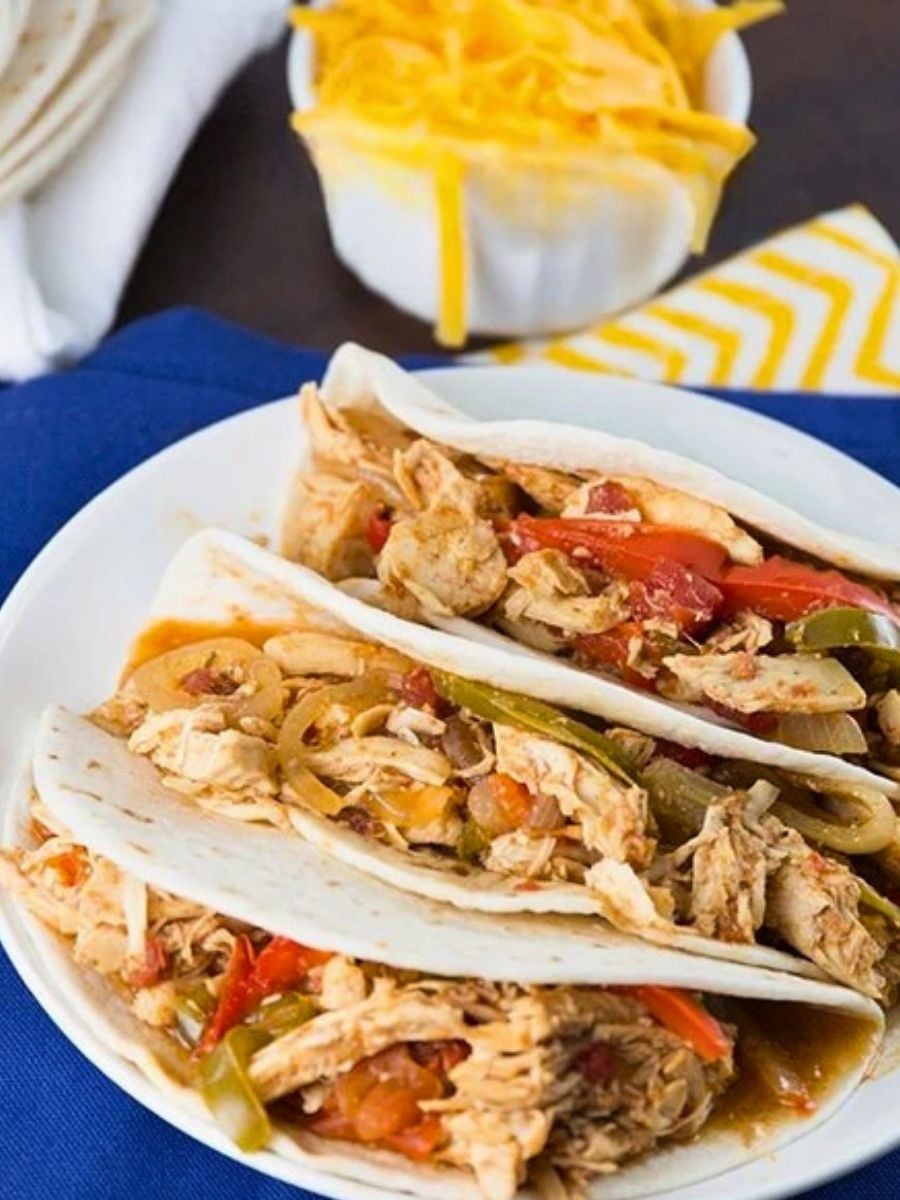 slow cooker chicken fajitas with shredded chicken, red and green peppers and warm tortillas