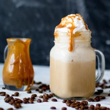 glass of starbucks caramel frappuccino copycat recipe with caramel sitting in background