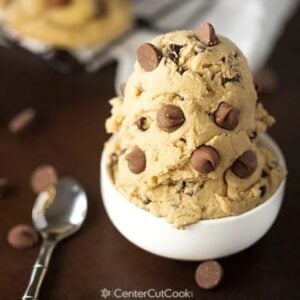 Edible Egg-less Chocolate Chip Cookie Dough in a bowl with a spoon and chocolate chips sitting beside.