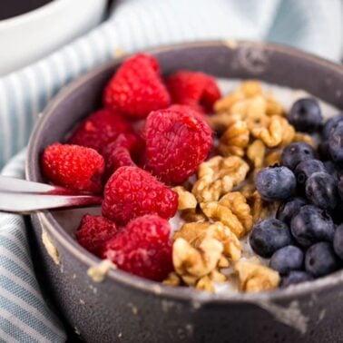 bowl of oatmeal made in the microwave topped with fresh berries and granola