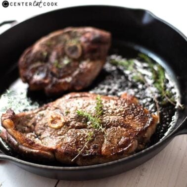 pan-seared thyme lamb steaks in a cast iron skillet