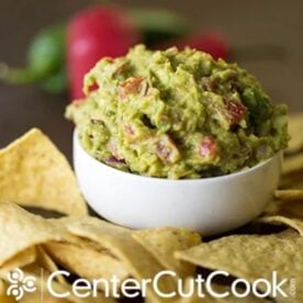bowl of the best guacamole surrounded by tortilla chips