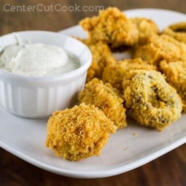 plate of crispy breaded mushrooms with dipping sauce on the side