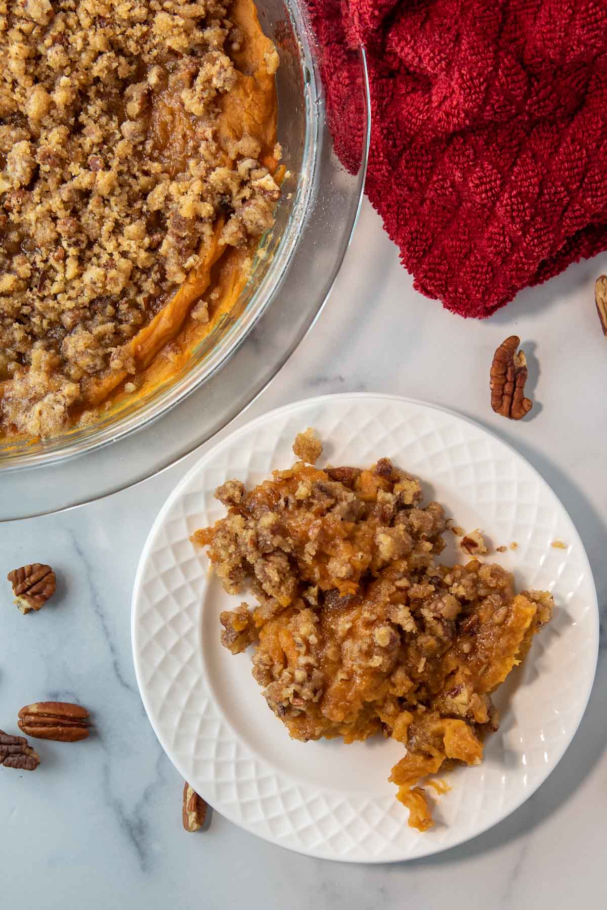 bowl of sweet potato casserole next to a plate of sweet potato casserole