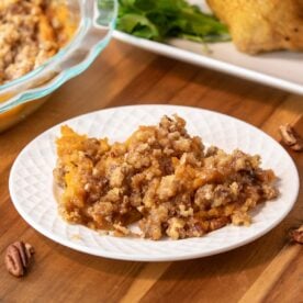 bowl of sweet potato casserole next to a plate of sweet potato casserole