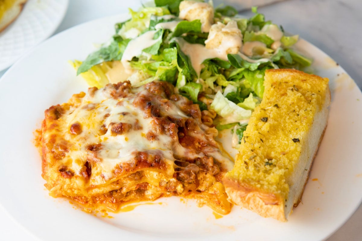 easy lasagna served with garlic bread and Caesar salad