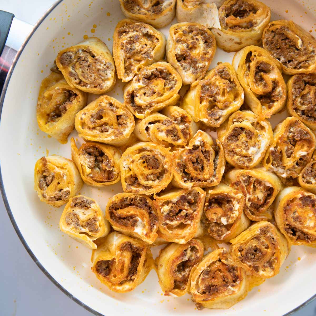 overhead of skillet of taco pinwheels