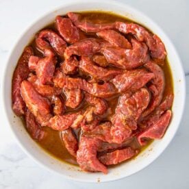 overhead of steak in a bowl of fajita marinade