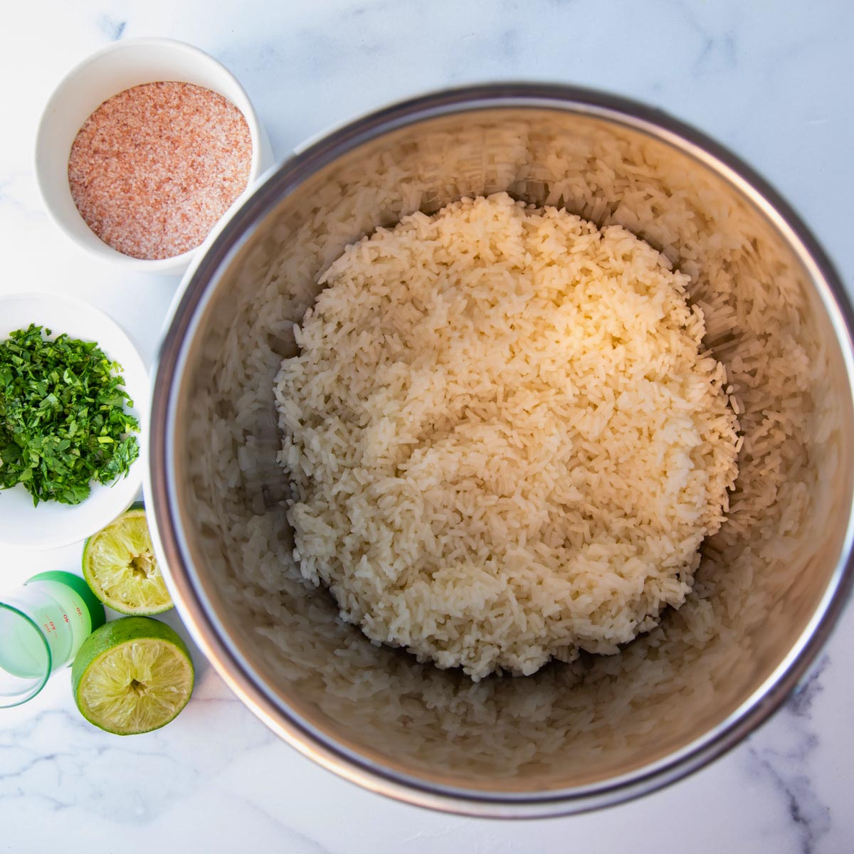 overhead of instant pot cilantro lime rice. Ingredients sitting beside.