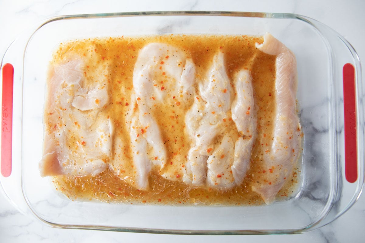 thin sliced chicken marinating in Italian dressing