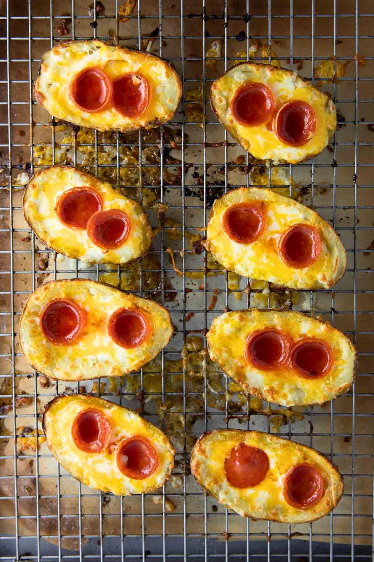 a baking tray with pizza potato skins sizzling in the oven