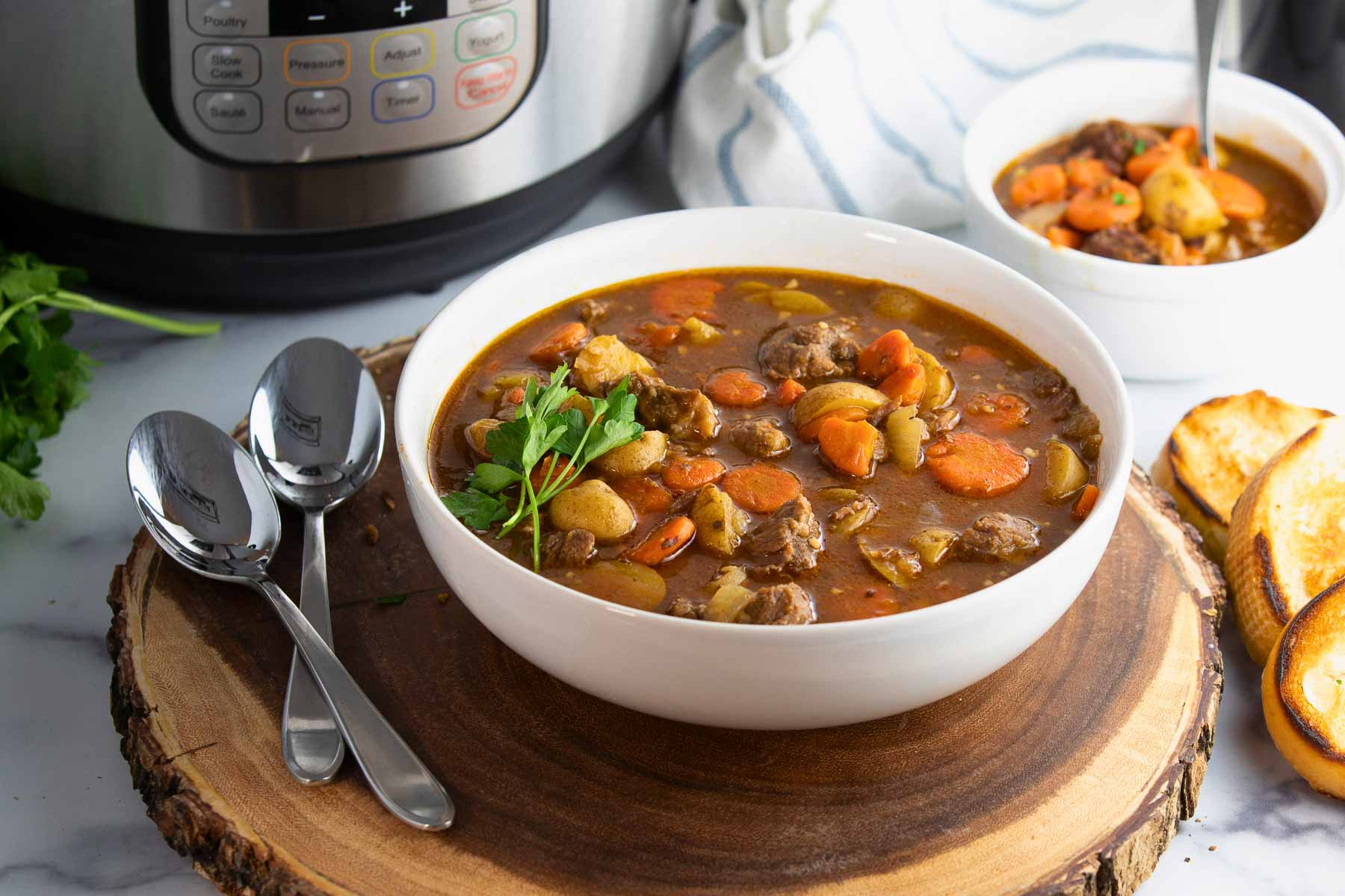 bowl of instant pot Irish beef stew with tender beef, potatoes and carrots in a rich Guinness broth.