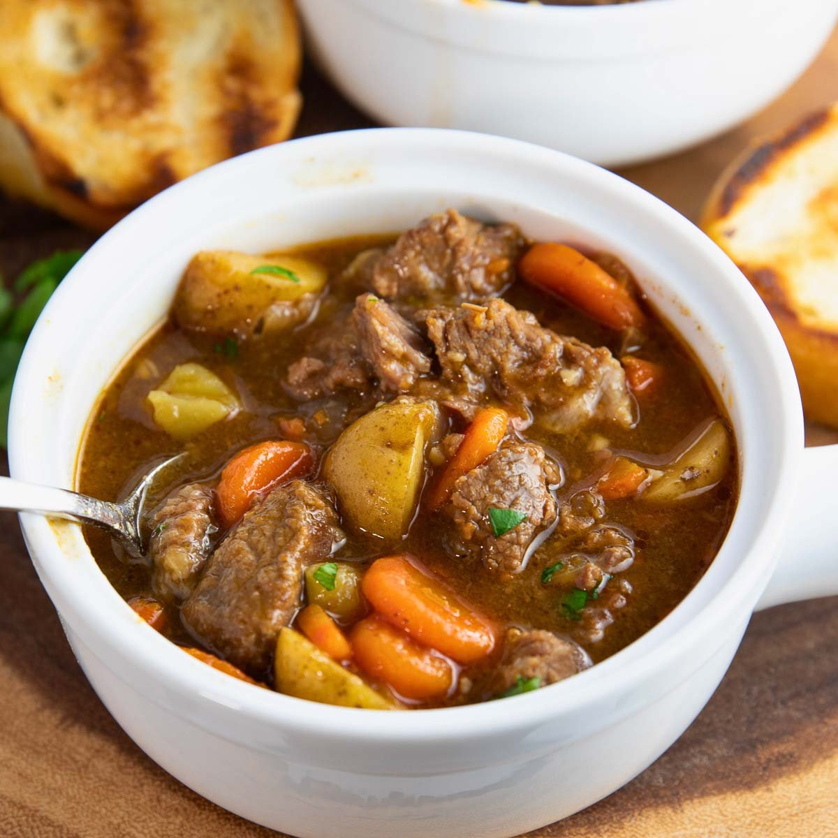 close-up of a spoonful of hearty Irish beef stew with chunks of beef and vegetables.