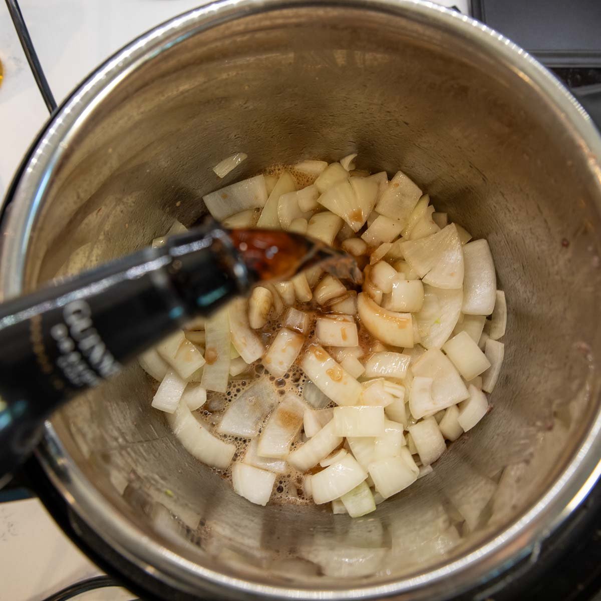 Deglazing the instant pot with Guiness beef and scraping up browned bits.