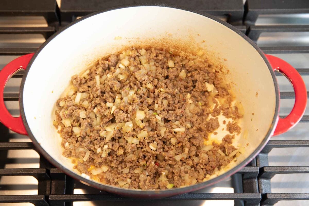 ground Italian sausage and onions browning in a skillet for soup