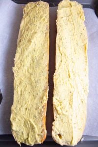loaf of French bread cut in half lengthwise, slathered with garlic butter