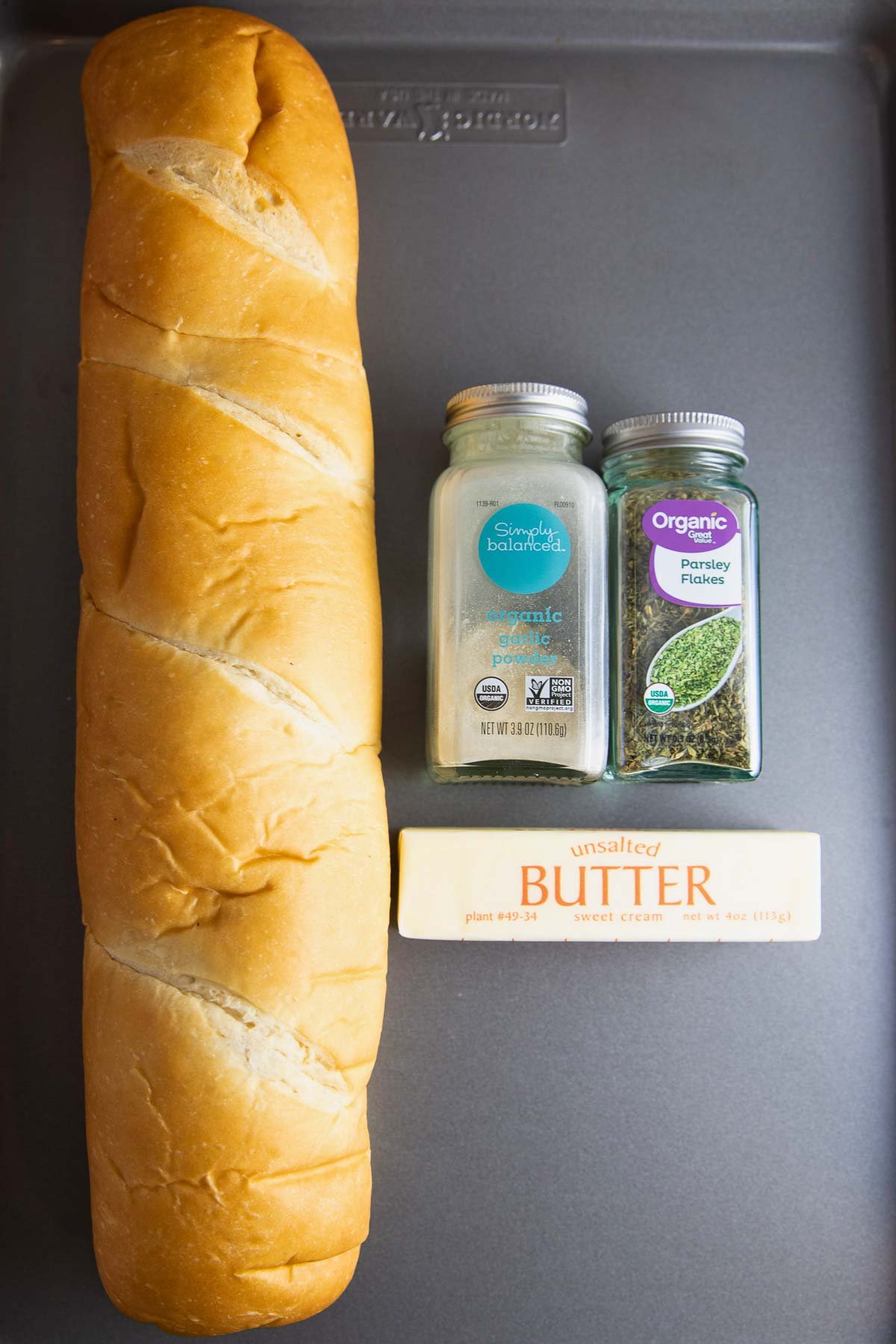 ingredients for garlic bread including French bread, garlic powder, and dried parsley.