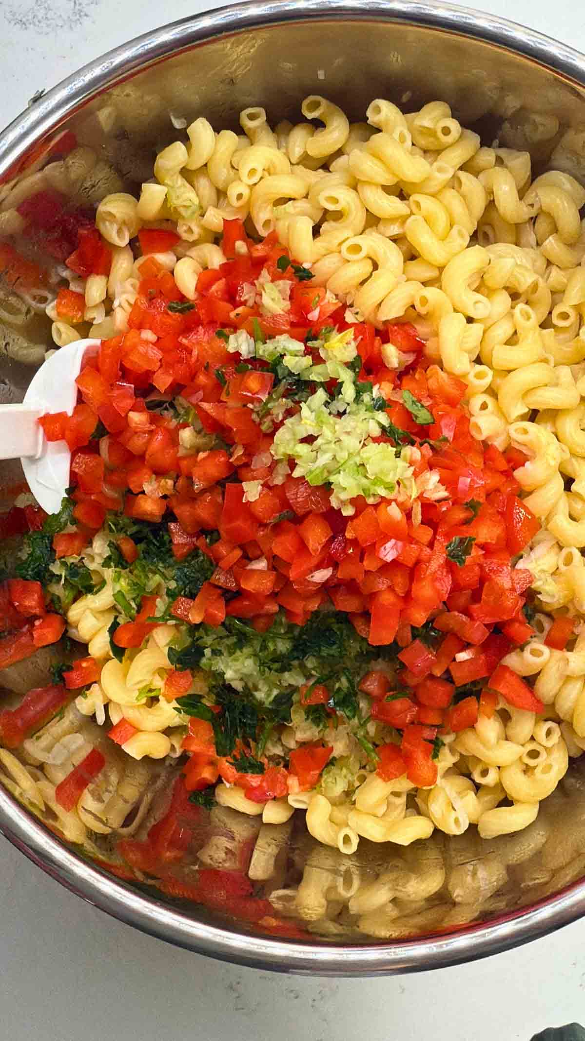 stirring macaroni salad ingredients together.