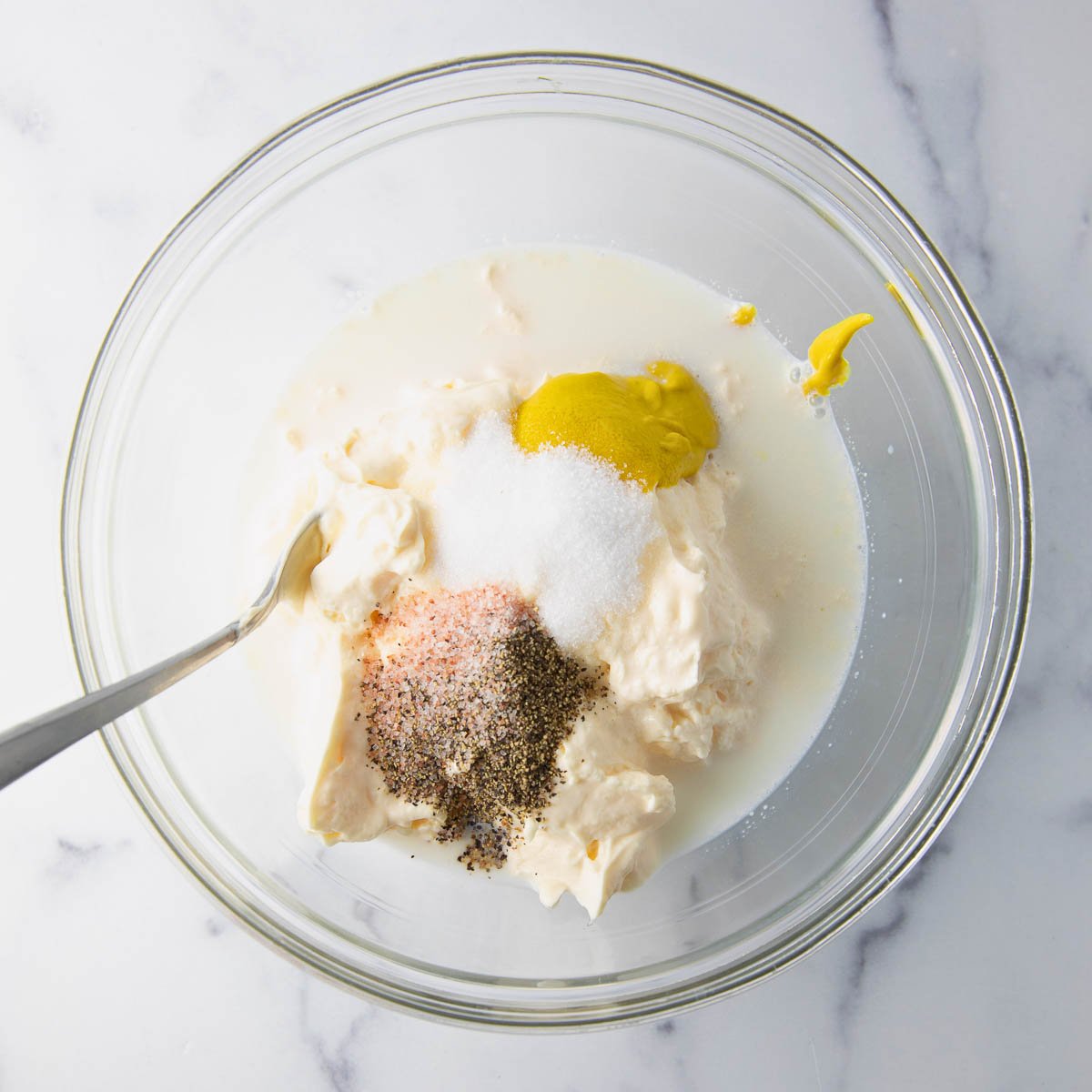 mixing mayonnaise dressing for macaroni salad in a bowl