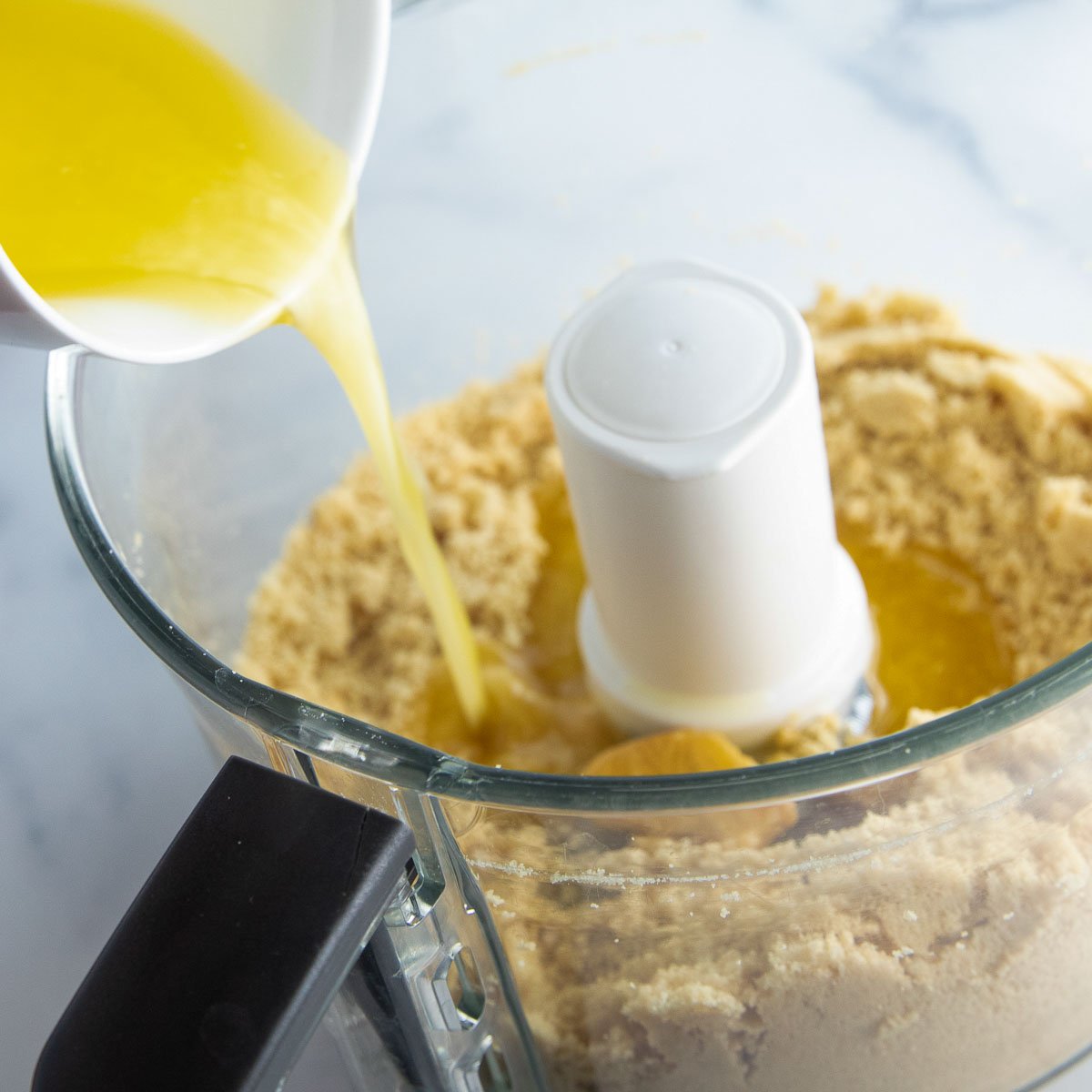 Combining butter with cookie crumbs to make a shortbread crust.