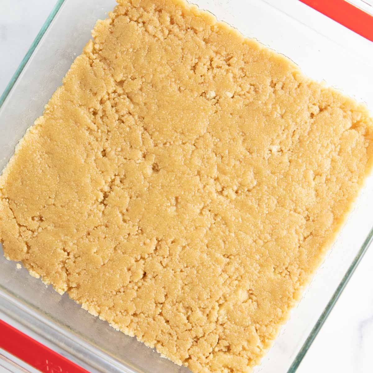 Combining cookie crumbs with butter to make the shortbread cookie crust.