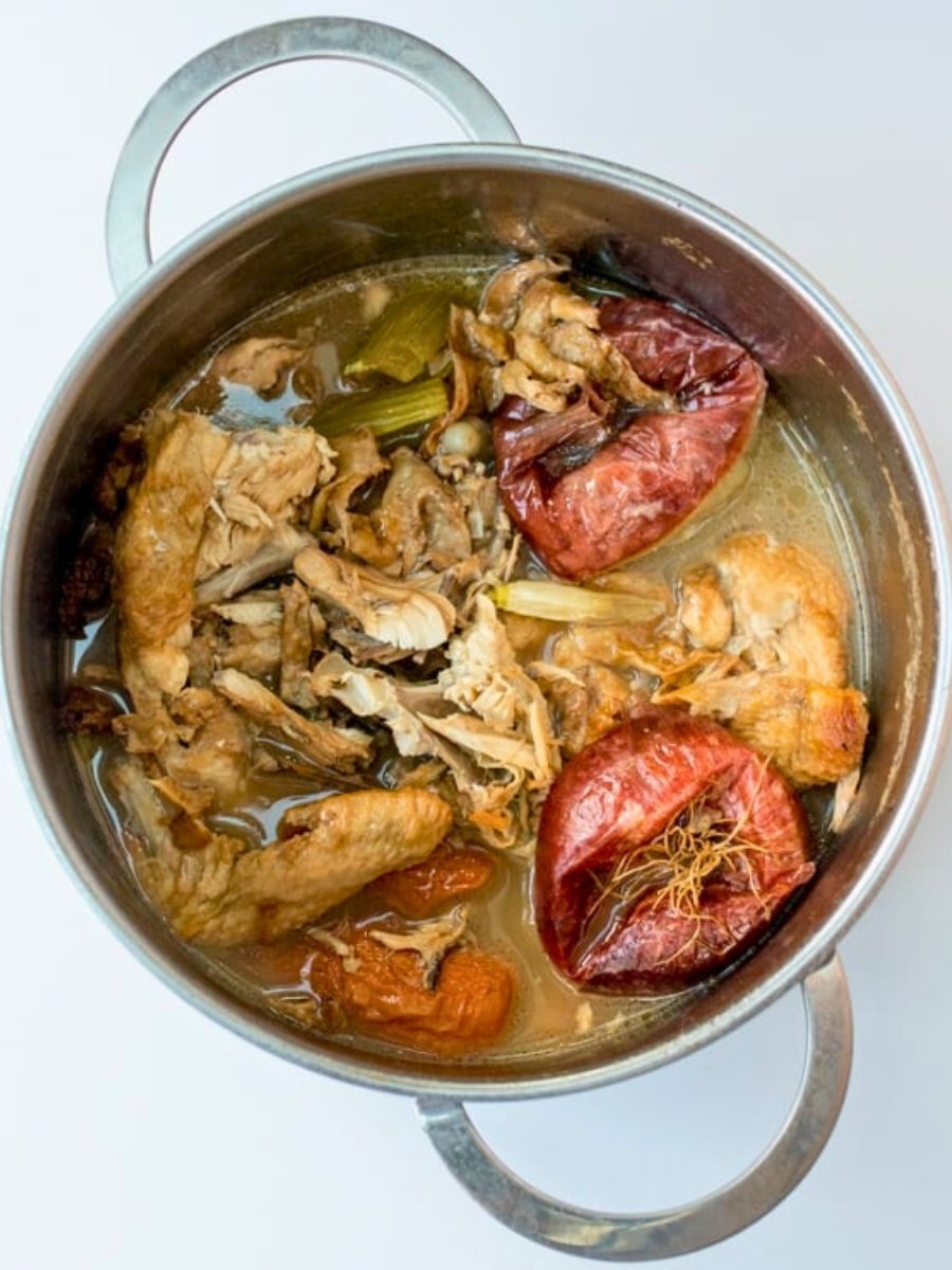 a large pot of chicken stock after it has simmered for 6 hours.