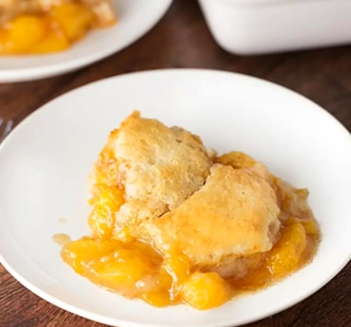 overhead view of fresh peach cobbler in a white baking dish