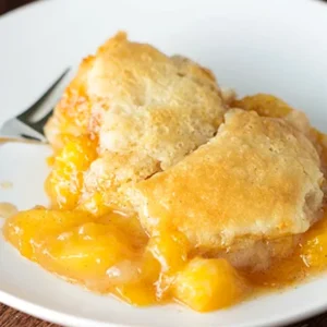 serving of easy fresh peach cobbler topped with vanilla ice cream