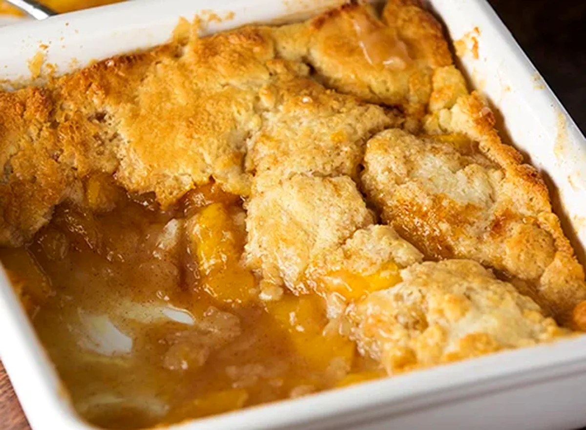 fresh peach cobbler with golden batter topping and sliced peaches